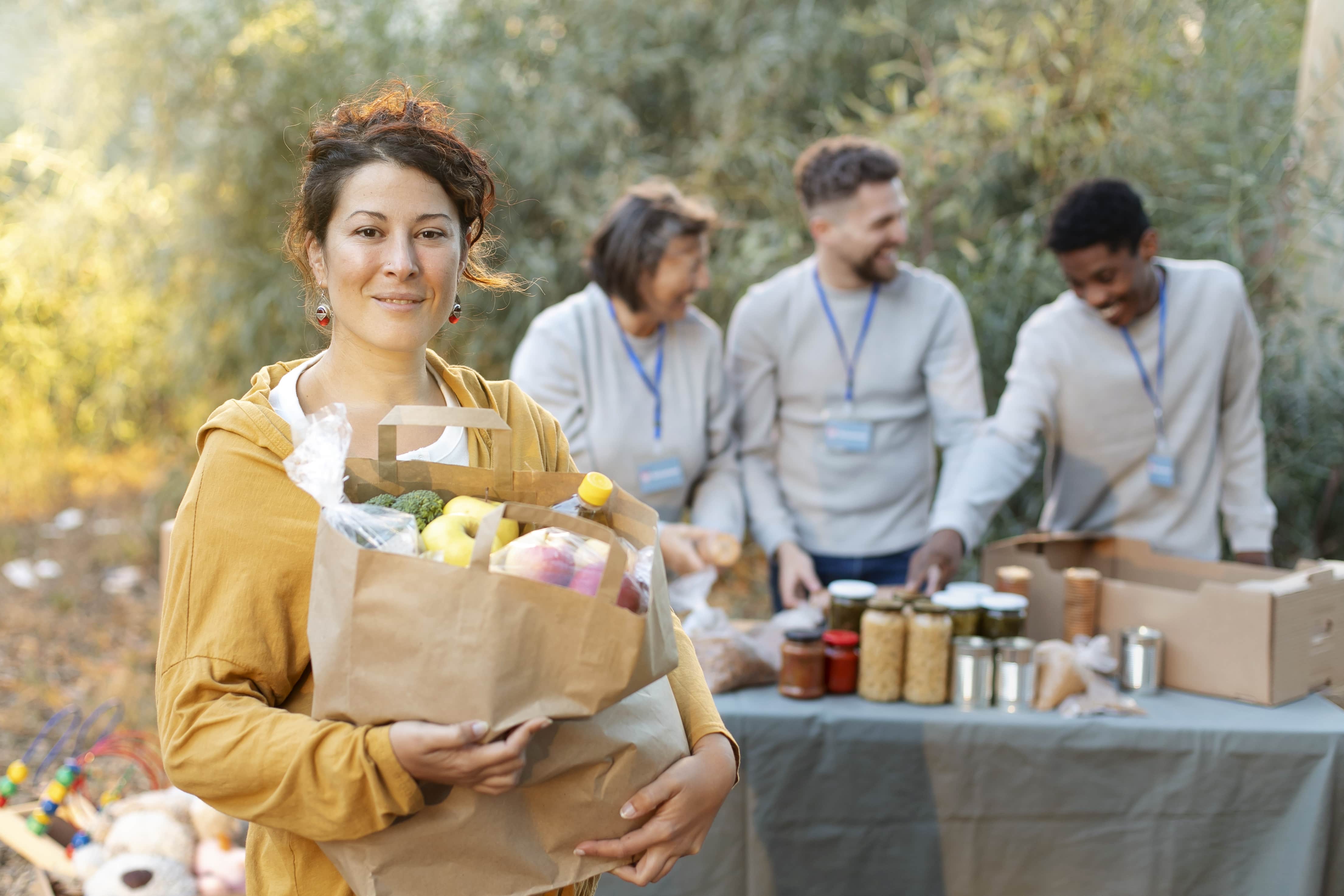 medium shot volunteers with food donations